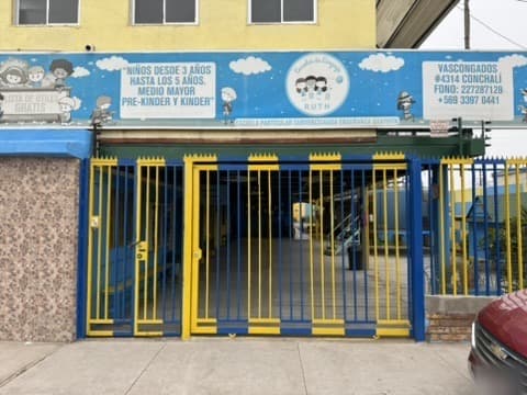 Acceso de la Escuela Vascongados con su reja azul y amarilla